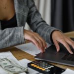 Budget Tips - A Woman in Plaid Blazer Using Her Laptop