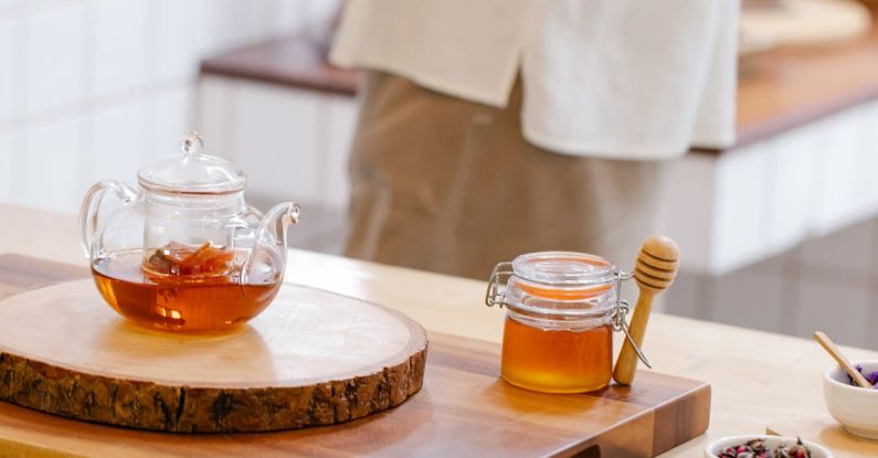 Tea Culture - Teapot and a Honey Jar with Spices on a Wooden Table